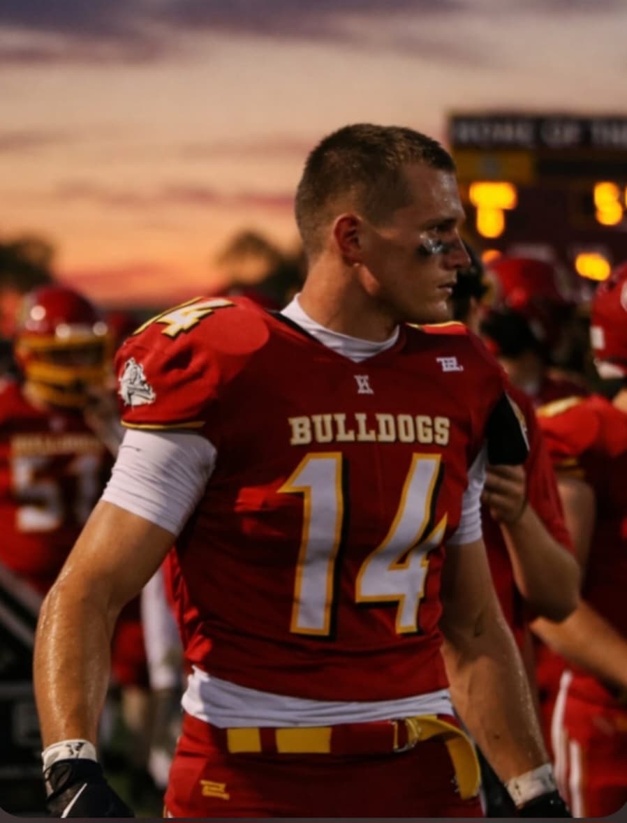 High school football player on the sideline at dusk